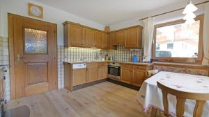 a kitchen with wooden cabinets and a table and a window at Sonnseit in Sankt Johann in Tirol