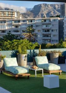 two chairs and a table on a balcony with a building at Zest Boutique Hotel by The Living Journey Collection in Cape Town