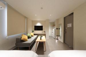 a living room with a couch and a table at MOMIJI TERRACE Hiroshima in Hiroshima +37 photos