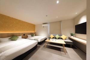 a hotel room with two beds and a tv at MOMIJI TERRACE Hiroshima in Hiroshima