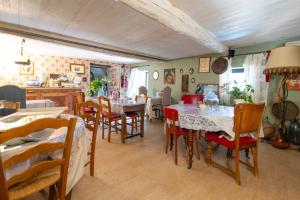a dining room with tables and chairs and a kitchen at Maison D'hôtes Casa Ghjunca in Rapale