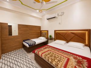 a bedroom with two beds in a room at Shri Mangal Palace in Gwalior