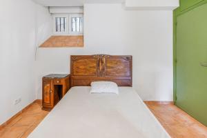 a small bedroom with a bed and a green door at Boni in Saint-Julien-Molin-Molette