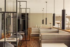 a restaurant with couches and tables and chandeliers at Falkensteiner Balance Resort Stegersbach l Adults Only in Stegersbach