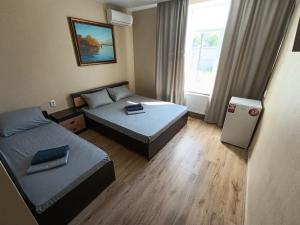 a small room with two beds and a refrigerator at Отель Гетьман in Broska