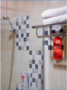 a bathroom with a shower with a red soap dispenser at Alqueby Hotel Bandung in Bandung