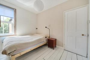 a white bedroom with a bed and a window at Victorian Terrace near Uni sleeps 6 Garden in Reading +11 photos