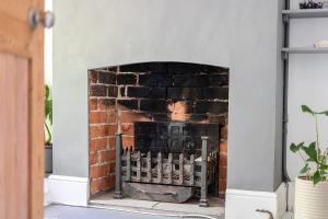 a brick fireplace in a living room at Victorian Terrace near Uni sleeps 6 Garden in Reading