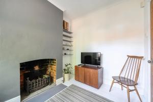a living room with a fireplace and a chair at Victorian Terrace near Uni sleeps 6 Garden in Reading