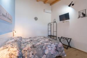 a bedroom with a bed and a tv on the wall at Baglio Netino in Noto