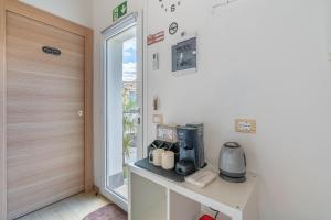 a room with a coffee maker on a table next to a door at Baglio Netino in Noto