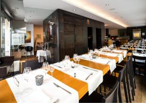 a row of tables in a restaurant with wine glasses at Les Negociants in Vevey