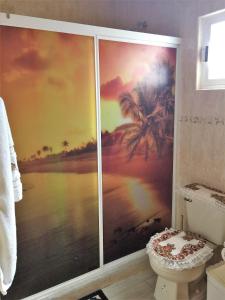 a bathroom with a mural of a beach and palm trees at Casa de la Tortuga in Zihuatanejo