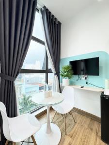 a living room with a table and chairs and a large window at Ngôi Nhà Mơ Ước in Ho Chi Minh City