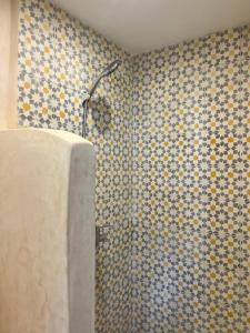 a bathroom with a shower with blue and yellow tiles at windora essaouira in Essaouira +42 photos