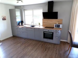 a kitchen with a sink and a microwave at Reetdachhaus 6, inkl 2 Parkplätze in Fehmarn