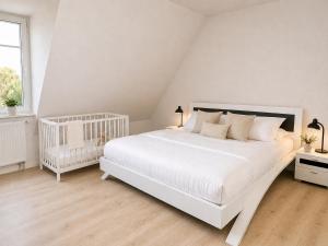 a white bedroom with a white bed and a window at Reetdachhaus 6, inkl 2 Parkplätze in Fehmarn +13 photos