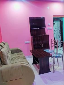 a living room with a couch and a table at Hotel Happy House in kolkata