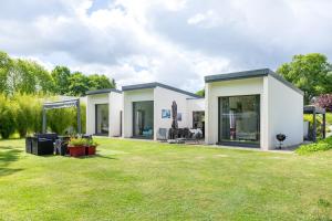 a house with a large yard at Sitelles Lodge Cube avec spa in Concarneau