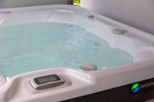 a bath tub filled with blue water in a sink at Sitelles Lodge Cube avec spa in Concarneau +37 photos