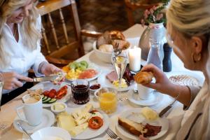 two women sitting at a table with plates of food at Romantik Hotel Hirschen in Parsberg