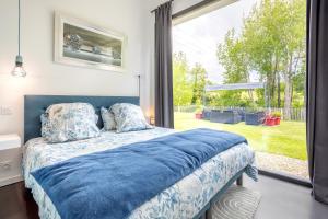 a bedroom with a bed and a large window at Sitelles Lodge Cube avec spa in Concarneau