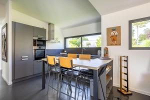 a kitchen with a table and chairs in a room at Sitelles Lodge Cube avec spa in Concarneau