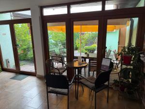 a dining room with a table and chairs and windows at Casa Aurelia in Sibiu