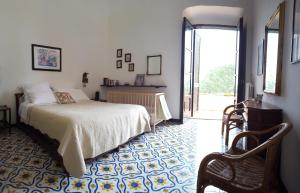 a bedroom with a bed and a chair in it at Il Casino Di Mare - Dimora Storica in Santa Maria di Castellabate