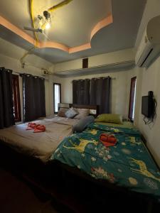 a bedroom with a large bed with two slippers on it at ภูมิคิมมินทร์ รีสอร์ท & สปา in Ban Chai Na