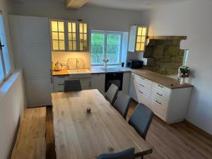a kitchen with a wooden table and chairs in it at Chalupa Hnízdo Jetřichovice in Jetřichovice