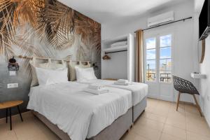 a bedroom with a large bed with white sheets at Bay's in Spetses