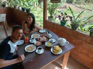 a man and a woman sitting at a table with food at Sigiriya Danu Homestay in Sigiriya