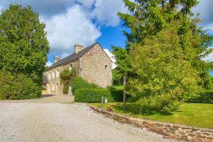 a stone house with a tree and a driveway at Chambres D'hôtes Dans Le Cotentin in Teurthéville-Bocage