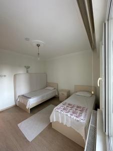 a bedroom with two beds and a window at AiRPORT TO THE HOTEL AND HOME in Pelitli