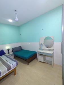 a room with two beds and a desk and a mirror at Heena in Kendhoo