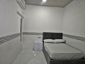 a small bedroom with a bed and a window at Heena in Kendhoo