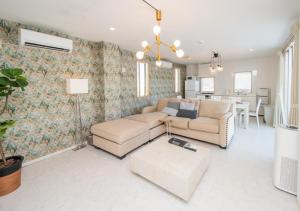 a living room with two couches and a dining room at MareStella残波 in Tokeshi