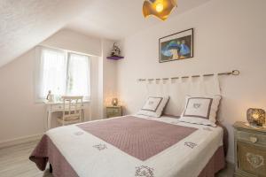 a bedroom with a bed with pink and white sheets at Chez Coco in Trégunc