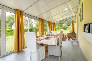 a dining room with a table and some windows at Chez Coco in Trégunc