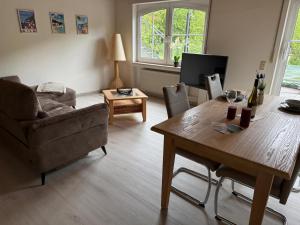 a living room with a table and a couch at Moseloase am Weinberg mit Pool und Sauna in Bullay in Alf