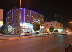 a city street at night with cars and buildings at شقق المربعة للشقق المخدومة in Ruqaiqah