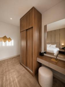 ein Schlafzimmer mit einem Bett, einem Schreibtisch und einem Spiegel in der Unterkunft تـرامونتـان للشقق المخدومة in Ha'il + 60 Fotos