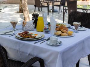 a table with plates of breakfast food on it at PHAKELA PRIVATE LODGE in Thabazimbi