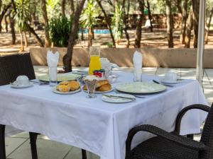 a white table with food and drinks on it at PHAKELA PRIVATE LODGE in Thabazimbi +4 photos