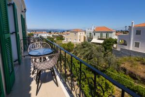a balcony with a chair and a view at Bay's in Spetses