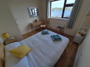 a large white bed in a room with a large window at Cuchulainn Townhouse in Galway