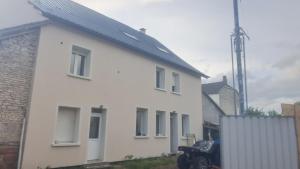 a white house with a car parked next to it at Les Coquillages in Essoyes
