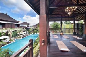 an outdoor deck with a pool and a pavilion at MĀUA OLEA Ubud by Swiss-Belhotel in Ubud