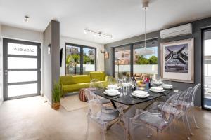 a dining room and living room with a table and chairs at Casa Seal by Briskva in Funtana
